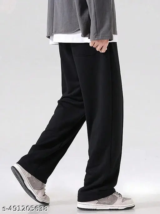 Person wearing black pants and gray shoes on a white background